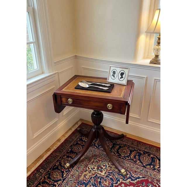 An authentic mid-century Mersman Table, this fully restored mahogany drop-leaf silverware chest table seamlessly pairs...