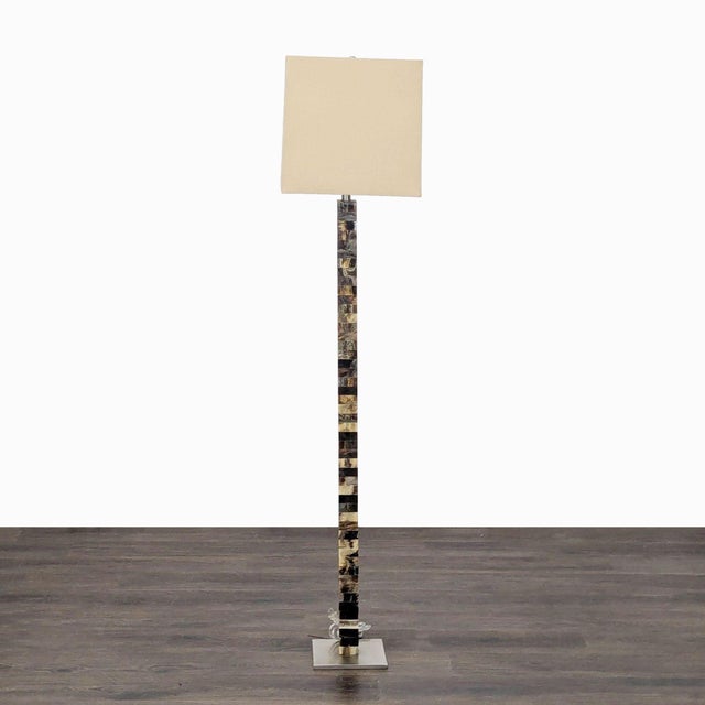 This Arteriors floor lamp features a striking column base with a unique mixed horn finish, showcasing natural patterns in...