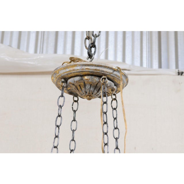 A French sixteen-light hanging circular chandelier. This vintage chandelier from France is stylized with a leaf motif...