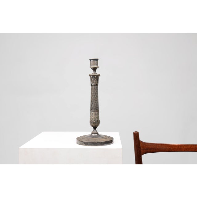 An elegant French Empire‑style candlestick dating to around 1900, crafted in silver‑plated copper and richly decorated...