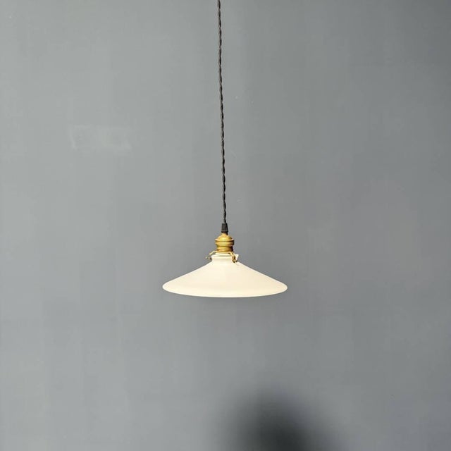 Antique white opaline glass bowl pendant lamp with a brass fixture. This one dates from the 1930s. The lamp has an...
