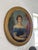 19th century oil portrait of a woman in an off-the-shoulder blue gown trimmed with lace, wearing a coral bead necklace,...