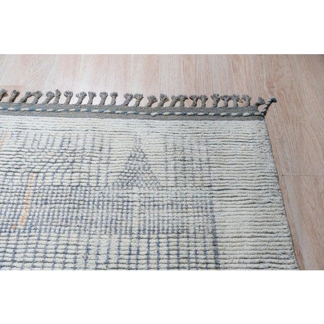 This hand knotted pile rug features a primary color palette of ivory, beige, cream, and white. Crafted from natural wool,...