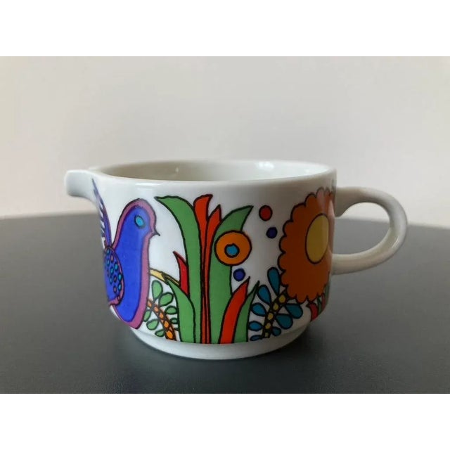 A beautiful and colorful creamer milk pitcher, circa mid-20th century, Luxembourg, Europe. A circular bird and flower...
