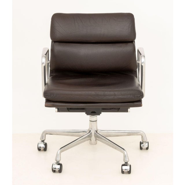 Charles and Ray Eames Soft Pad Management Chair, with dark brown leather upholstery and aluminum frame on star base. 31" H...