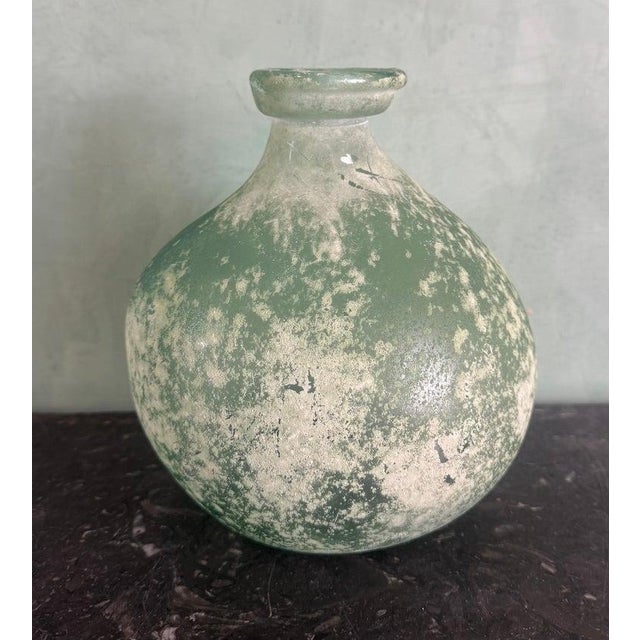 A hand-blown glass vase from Spain, characterized by its elegant, rounded gourd-form body and gently flared collar neck....