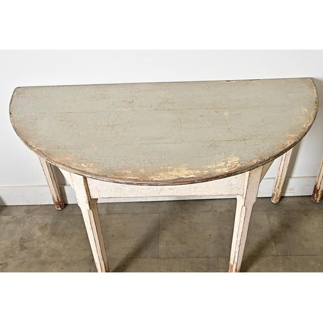 Wonderful turn of the century (circa 1900) pair of Swedish half-circle painted console tables in that weathered craquelure...
