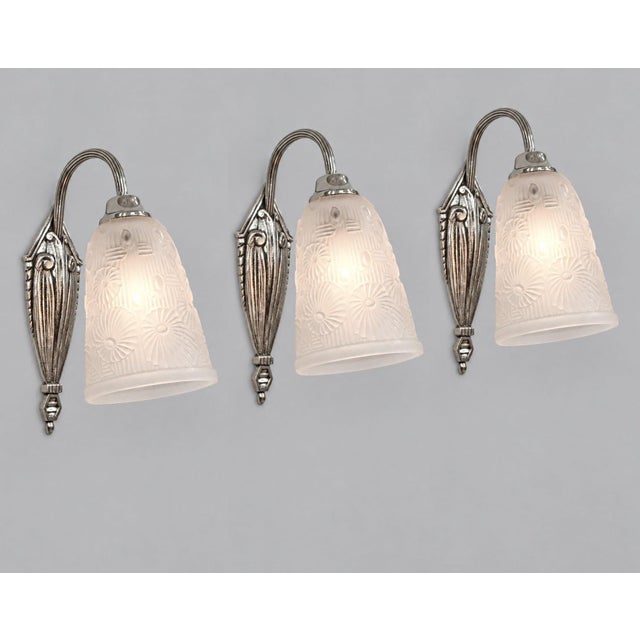Lorrain Daum A set of three French art deco floral motif wall sconces circa 1925-1935 in nickel-plated cast bronze or...