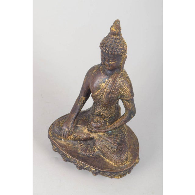Gilt bronze Buddha figure. Seated Buddha figure executed in gilt bronze with a meditative pose, detailed ornamental...