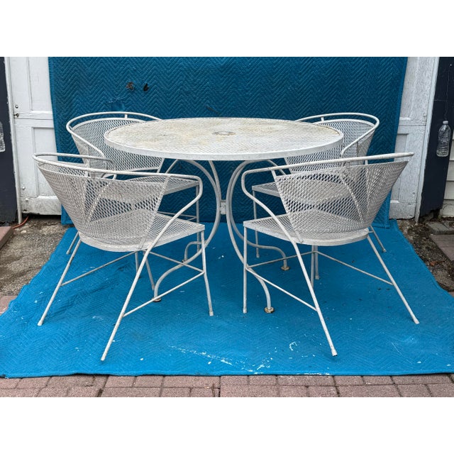 round mesh table and four sculptural armchairs that fully lean into the era’s signature lines. The chairs showcase the...