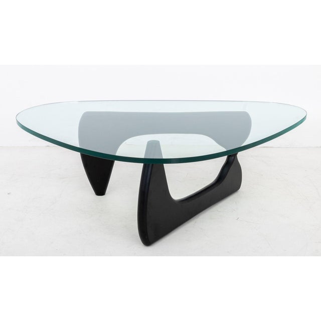 Isamu Noguchi Style Amorphic Coffee Table, rounded edge triangular glass top above ebonized hinged wood base, marked...