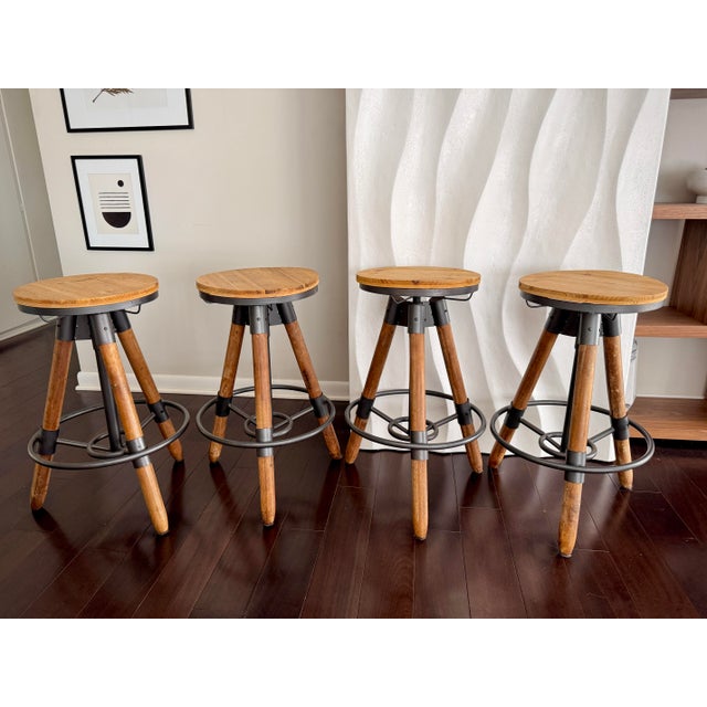 Set of 4 Industrial Tripod Legs Cb2 Acacia Wood Round Seat Adjustable Counter Stools With Wrought Metal Hardware For Sale In Los Angeles - Image 6 of 12