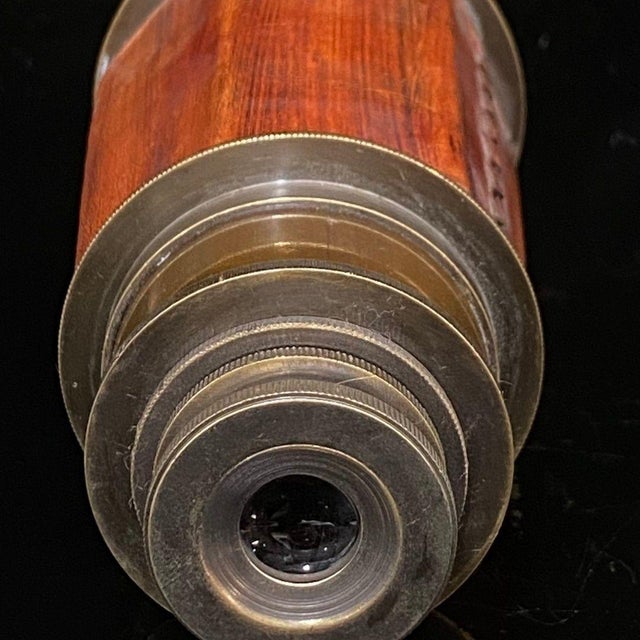 This striking antique telescope, or spyglass, is a fine example of vintage optical craftsmanship. The body features a...