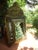 A small brush cabinet, richly decorated with embossed brass sheeting, the central mirror with a beveled edge, is...