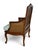 This is a Louis XV style caned bergère chair featuring a carved walnut frame with gracefully scrolled arms, flowing...