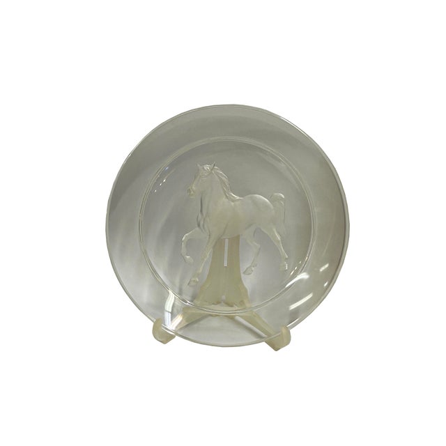 This elegant, clear glass decorative plate features a striking frosted-relief sculpture of a horse at its center. The...