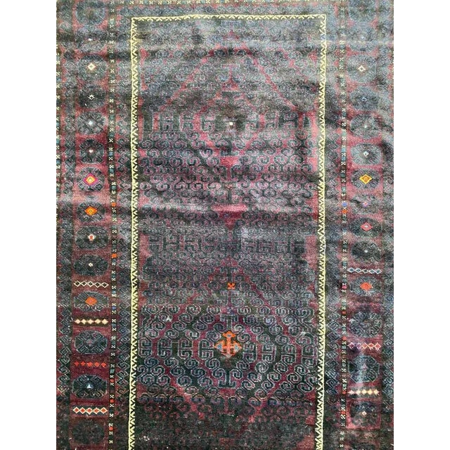 Midcentury Baluch Afghan rug with tribal design and dark colors, entirely hand knotted with wool velvet on wool foundation.