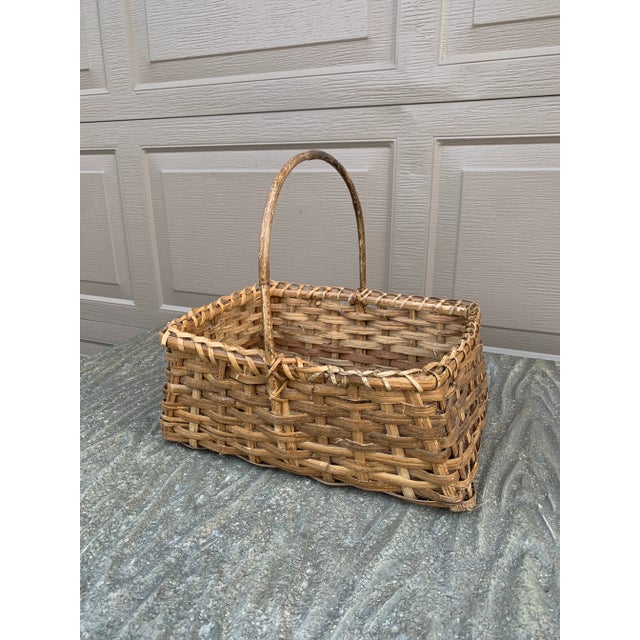 A beautifully woven early 20th century American splint oak basket with warm honeyed tones and a tightly constructed...