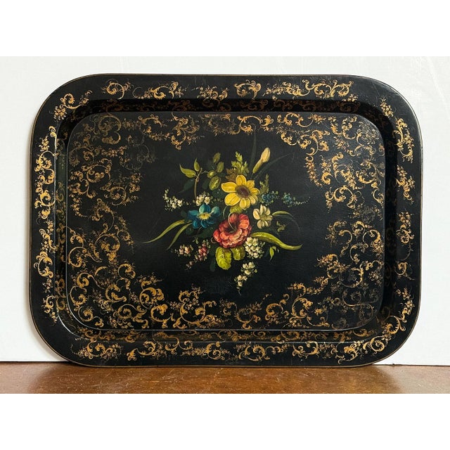 A fine large English black lacquered papier-mâché tray from the Aesthetic Movement period, featuring a decorative painting...