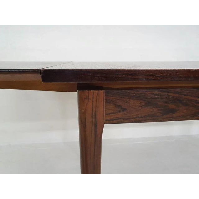 Rosewood veneer dining table with two extension leaves. Probably from Germany. The top has been sanded and lacquered. On...
