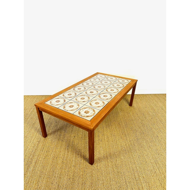 Elegant Scandinavian-inspired coffee table from the 1960s. The frame is made of solid teak and teak veneer, offering a...