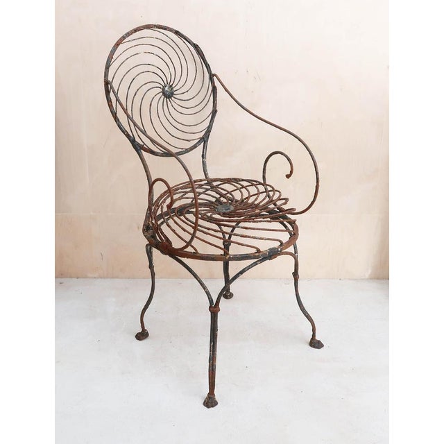 Fabulous wrought iron garden chair with the distinct spiral pinwheel design on the back and seat. Spring seat. Traces of...