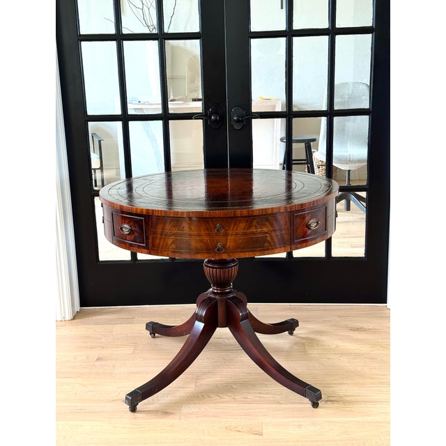 Elegant vintage Regency-style drum table featuring a rich mahogany finish, a classic round top, and a single drawer for...
