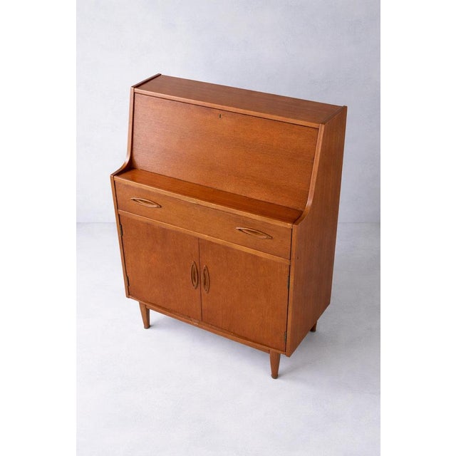 This mid century teak desk by Jentique combines classic British modernist furniture design with practical function, ideal...