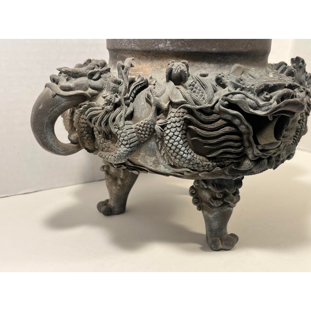 This antique incense burner showcases incredible craftsmanship, with detailed dragon carvings, a guardian figure, and a...