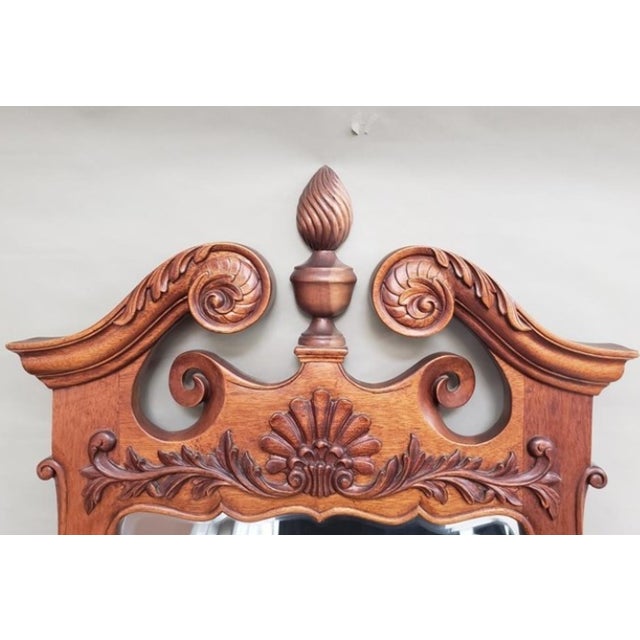 This stunning late 20th-century beveled wall mirror perfectly captures traditional Chippendale style with a rich walnut...
