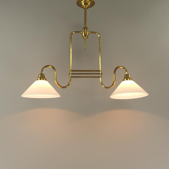 Massive Brass Two-armed hanging lamp for dining or game table with opal glass shade Polished surface. The light has been...
