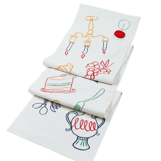 Draw the eye down the center of your table with 100-percent linen covered in bright, playful embroidery inspired by simple...