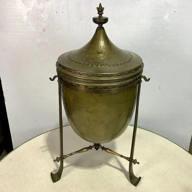 Regency style bronze celleratte, of circular form, with removable lid, revealing a black painted tin liner, resting in a...