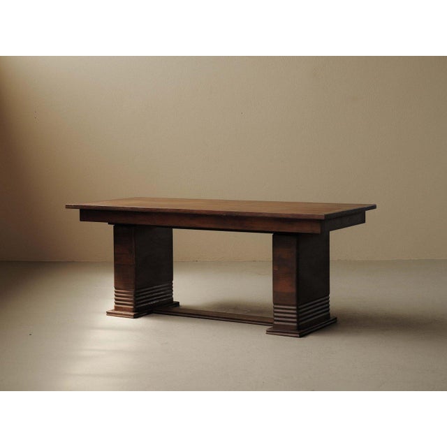 Dining table, crafted in France around 1940, is made of solid wood and veneer in a rectangular form. It rests on two solid...