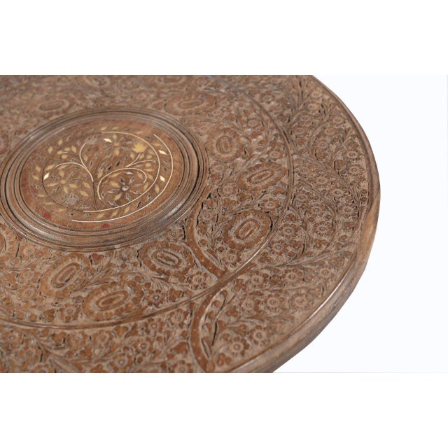 This Vintage Moroccan Style Side Table features a richly carved round top with elaborate floral and geometric motifs,...