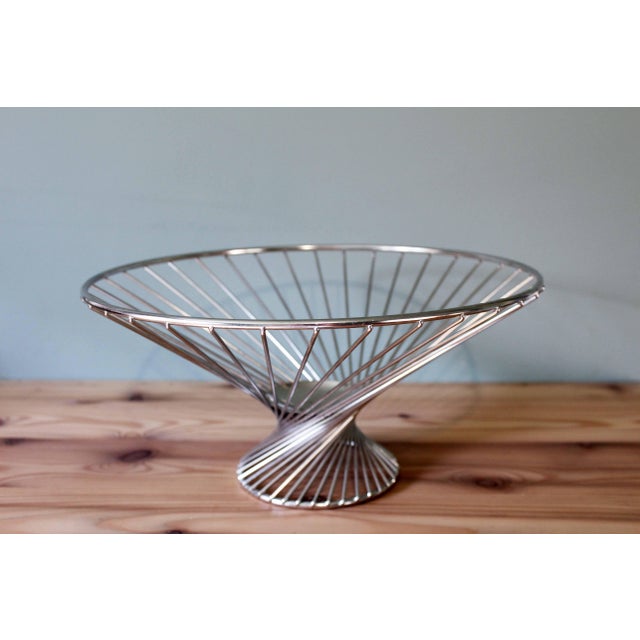 This elegant fruit bowl is a creation of the renowned German manufacturer WMF, celebrated for its excellence in metalwork....