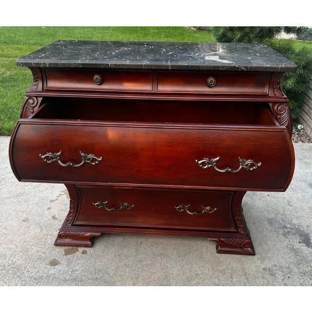 A Bombay® Furniture Co. Marble Top Bombe Chest in a Classic French