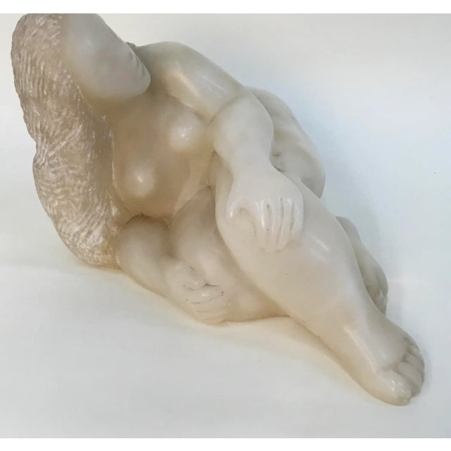 Beautiful hand carved sculpture of a reclining nude .