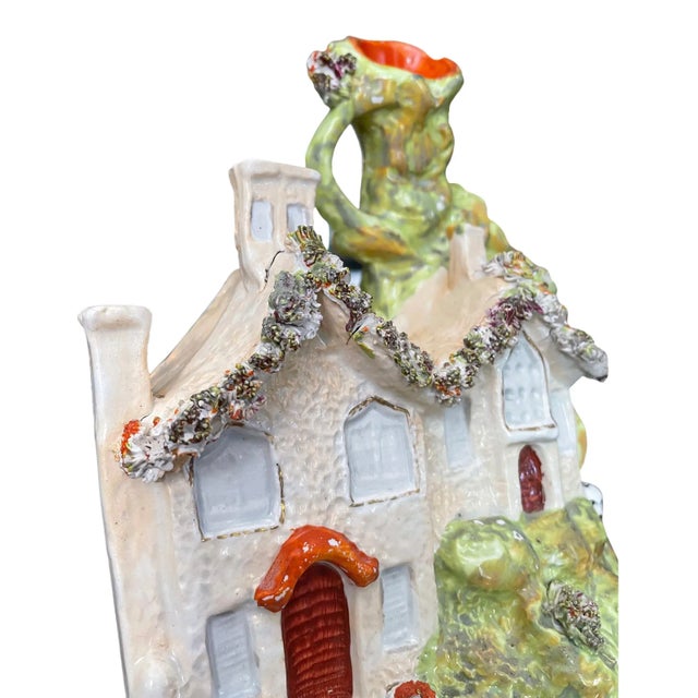 A Charming Staffordshire pottery pastille burner. In the form of a house featuring sculpted flowers and a dog chasing a...
