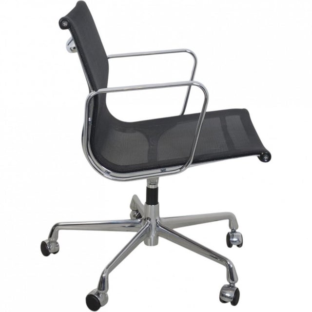Charles Eames EA-117 office chair upholstered in black mesh, with chrome armrests and frame. The chair is from 2002 and...