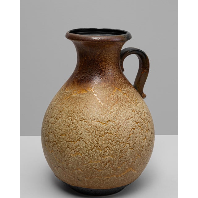 This 20th-century German ceramic vase, stamped W. Germany, showcases the organic textures and earthy palette that...