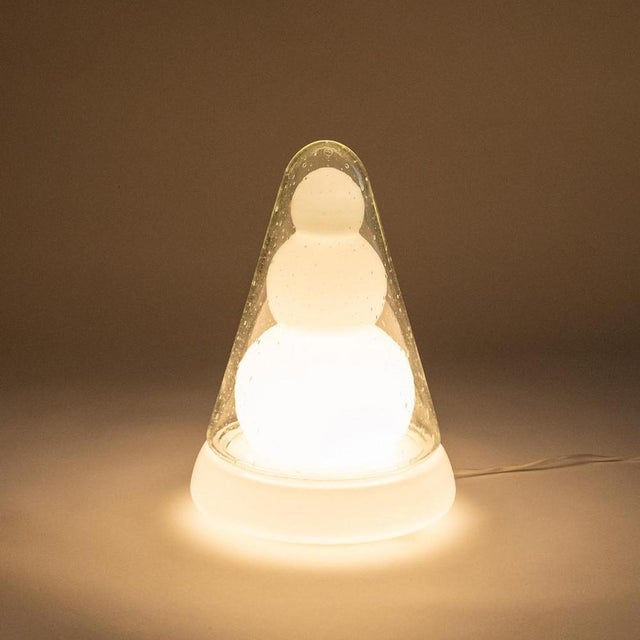 Atypical table lamp made of several layers of glass. The shaped inner part in frosted glass is covered by a rounded needle...