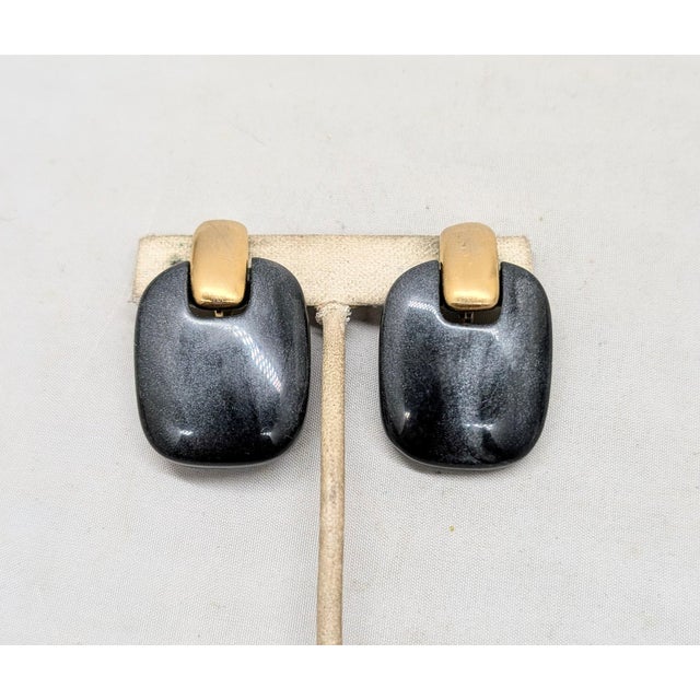 Late 1970s or early 1980s goldtone and rectangular black/silver sparkly hematite like resin drop clip earrings. Marked...