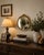 Elegant vintage Hollywood Regency round wall mirror featuring a beautifully detailed antiqued gold frame with braided...