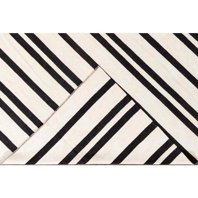 Beautiful 21st century contemporary Kilim rug, handwoven wool in an allover black and white striped design. This rug...
