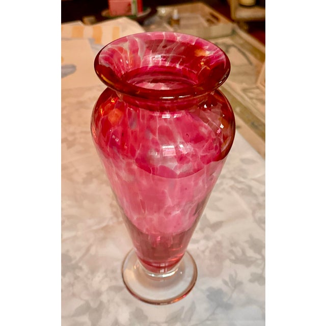 A striking hand‑blown art glass vase showcasing a vivid marbled palette of pink, fuchsia, orange, and soft gold. The...