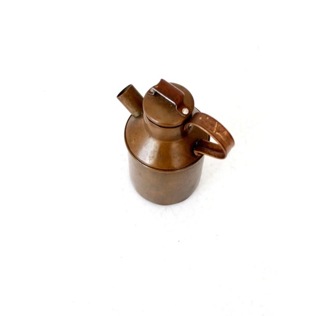 This antique copper pitcher or creamer features a charming handled lid, an oversized open spout, and a smooth rounded...