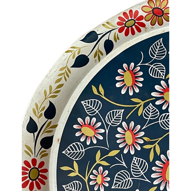 Add a vibrant vintage accent to your entertaining collection with this round metal serving tray featuring a bold floral...