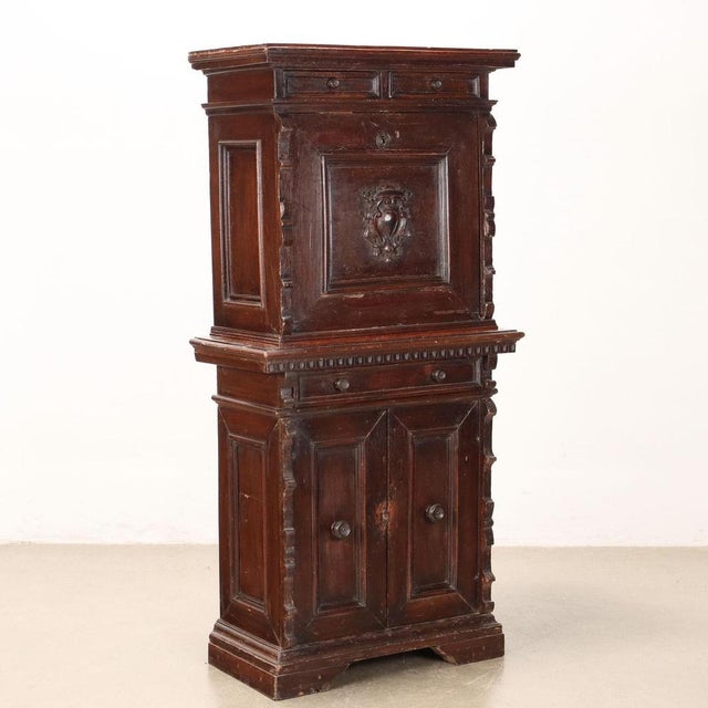 Neo-Renaissance cabinet supported by bracket feet, on the front it has two paneled doors and a drawer, raised with flap...