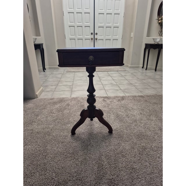 This is a federal or Duncan Phyfe style side table featuring a turned pedestal base and tripod legs. This table includes a...